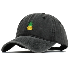 Detail of pineapple embroidery on vintage washed cotton baseball cap with curved brim