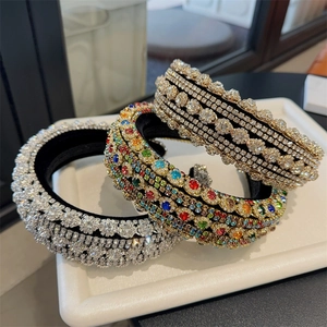 Three baroque padded headbands with colorful rhinestones and crystals on a white tray