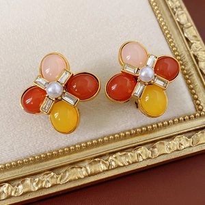 Vue macro de boucles d'oreilles vintage avec pierres colorées et perle centrale