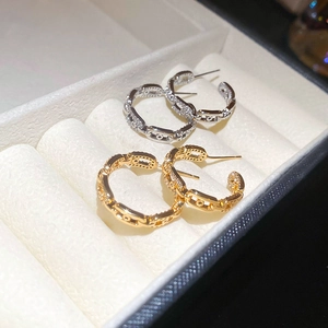Detail of gold and silver chain earrings with pavé crystals in a velvet jewelry box
