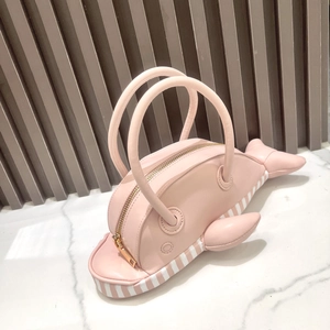 Detail shot of the pink whale shaped handbag with zipper and striped bottom trim