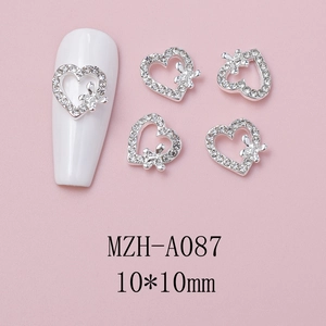 Macro shot of silver alloy bow nail charm with hollow heart and rhinestones, 10x10mm