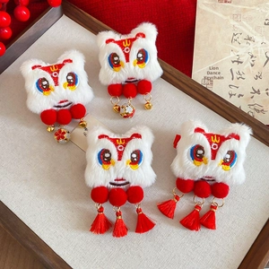 Detail of four festive Chinese lion dance hair clips with plush texture and red tassels