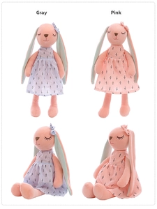 Detail showing plush rabbit dolls in floral dresses with closed eyes and soft fabric textures