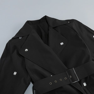 Détail du revers de la robe noire et de la ceinture avec boucle en strass carrée