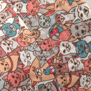 Macro detail of cartoon cat print fabric with white stitching on a bucket hat