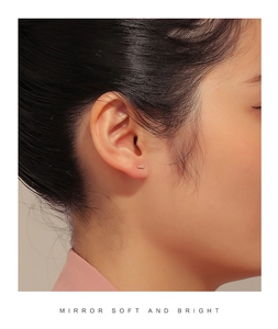Close-up of minimalist gold bar stud earring with micro-pave zircons on model ear