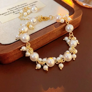 French style pearl cluster bracelet with gold chain on a rustic wooden tray display