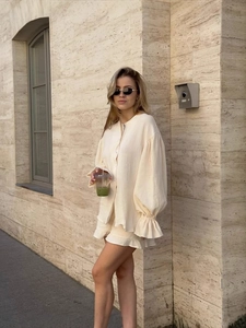 Ensemble chic deux pièces crème avec chemisier manches longues et jupe à volants taille haute