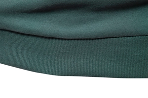 Detailed macro view of dark green knitted fabric with elastic ribbed cuffs and hem