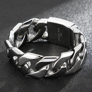Macro detail of silver 316L stainless steel Cuban link bracelet with engraved clasp