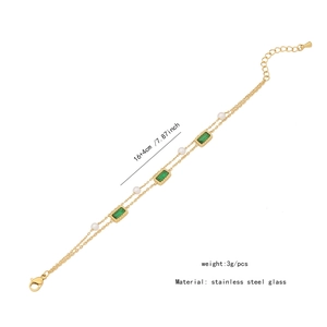 Golden double-layer bracelet featuring emerald green glass and white faux pearls