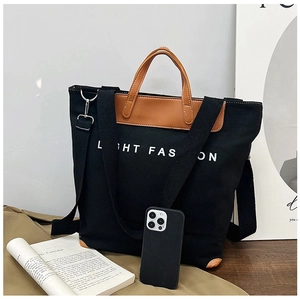 Detail view of large canvas tote bag showing inner zipper pocket and brown leather handles