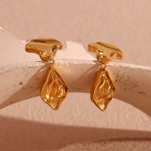 Detail shot of irregular abstract lava style gold plated earrings on stone base
