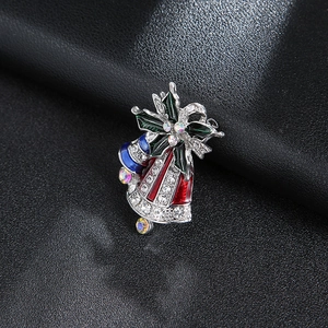 Close-up of Christmas bell brooch with colorful enamel and sparkling rhinestones
