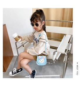 Close-up of light blue leather kids crossbody bag with cute white rabbit head and strap