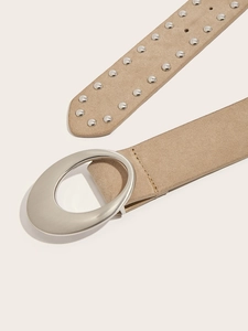 Détail d'une ceinture en daim kaki avec boucle ovale argentée et rivets métalliques