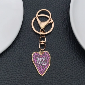 Détail macro du pendentif cœur léopard violet avec texte Love you sur porte-clés doré