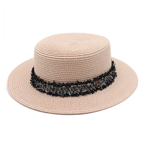 Detailed close-up of a flat top straw boater hat with tweed band and golden M buckle