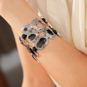 Macro detail of vintage silver-tone geometric bracelet with black textured resin inlay