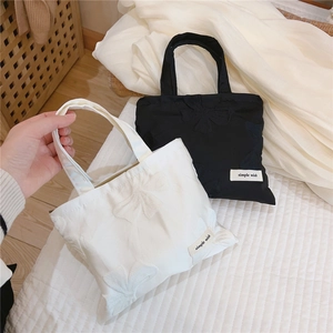 Detail of simple wish label on mini jacquard bow canvas tote with 3D embossed texture