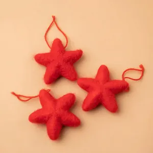 Three red wool felt star ornaments with strings for Christmas holiday decorations