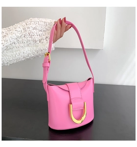 Close-up of pink shoulder bag with gold D-ring buckle and premium leather texture