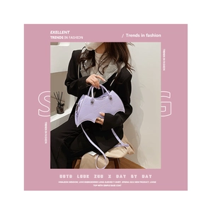 Detail of purple bat-shaped faux leather handbag featuring spider web stitching