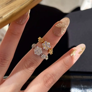 Macro shot of two floral cluster rings in gold and silver finish with sparkling stones