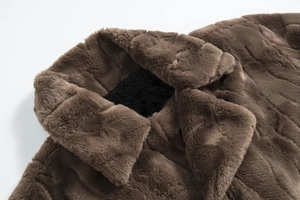 Detail shot of luxury dark brown faux fur coat showing wide collar and smooth shoulder texture