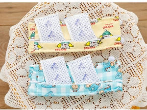 Detail of yellow and blue cartoon print cooling bags with zippers on a lace background