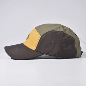 Detail of multi-color five-panel camping cap with breathable holes and peak print
