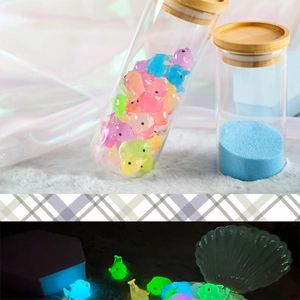 Glow-in-the-dark resin dolphin figurines in glass bottle showing night luminescence