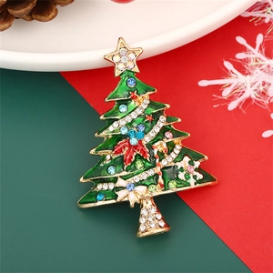 Green enamel Christmas tree brooch with colorful rhinestones on festive holiday backdrop