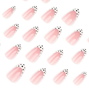 French press-on nails with almond shape, pink base and black polka dot white tips.