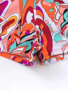 Detail of high-stretch floral print swim shorts showing flatlock stitching and vibrant pattern