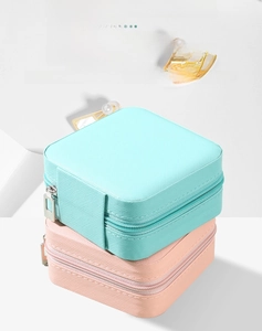 Detail of portable jewelry box with zipper closure in mint green and light pink