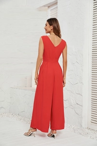 Detail view of red sleeveless wide-leg jumpsuit featuring a V-back and pleated texture
