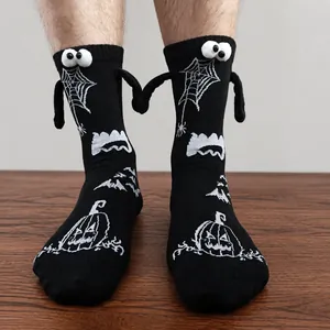 Detail of Halloween socks with 3D eyes and magnetic hands showing pumpkin patterns