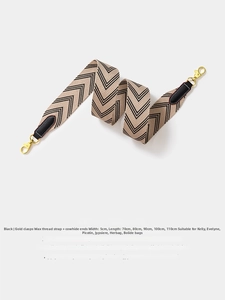 Detail of wide woven shoulder strap in black and beige with gold metal swivel snap hooks