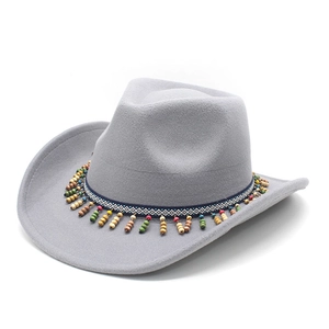 Detail of grey felt cowboy hat with ethnic woven band and colorful wooden bead tassels