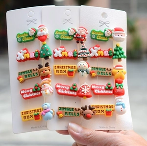 Close-up of colorful Christmas hair clips featuring Santa and elk on card packaging