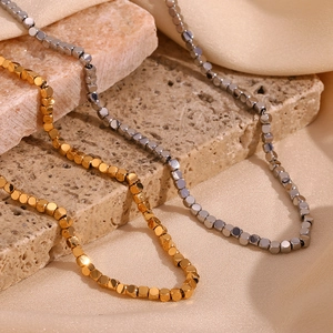 Minimalist square cube bead necklaces in gold and silver finish on stone background