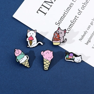 Detailed close-up of cartoon cat ice cream enamel pins on textured navy background