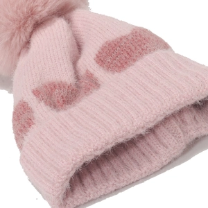 Pink winter knit baby hat with a large faux fur pom-pom and soft heart pattern texture
