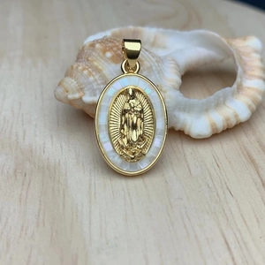 Macro shot of oval gold Guadalupe pendant with mother of pearl inlay on seashell