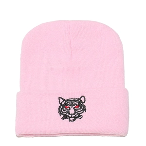 Close-up of pink knit beanie featuring detailed tiger head embroidery on the folded cuff
