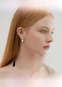 Fashionable Moissanite round hoop earrings in silver worn by a model in a side profile