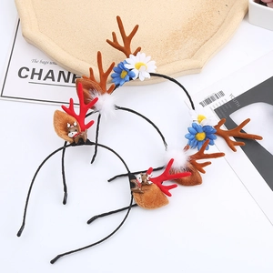 Detail view of two Christmas reindeer antler headbands with floral and deer doll accents