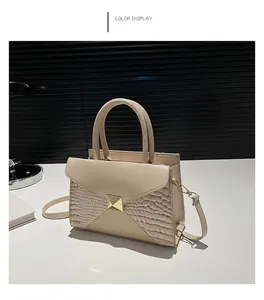 Detail view of khaki tote bag with crocodile pattern and golden metal buckle
